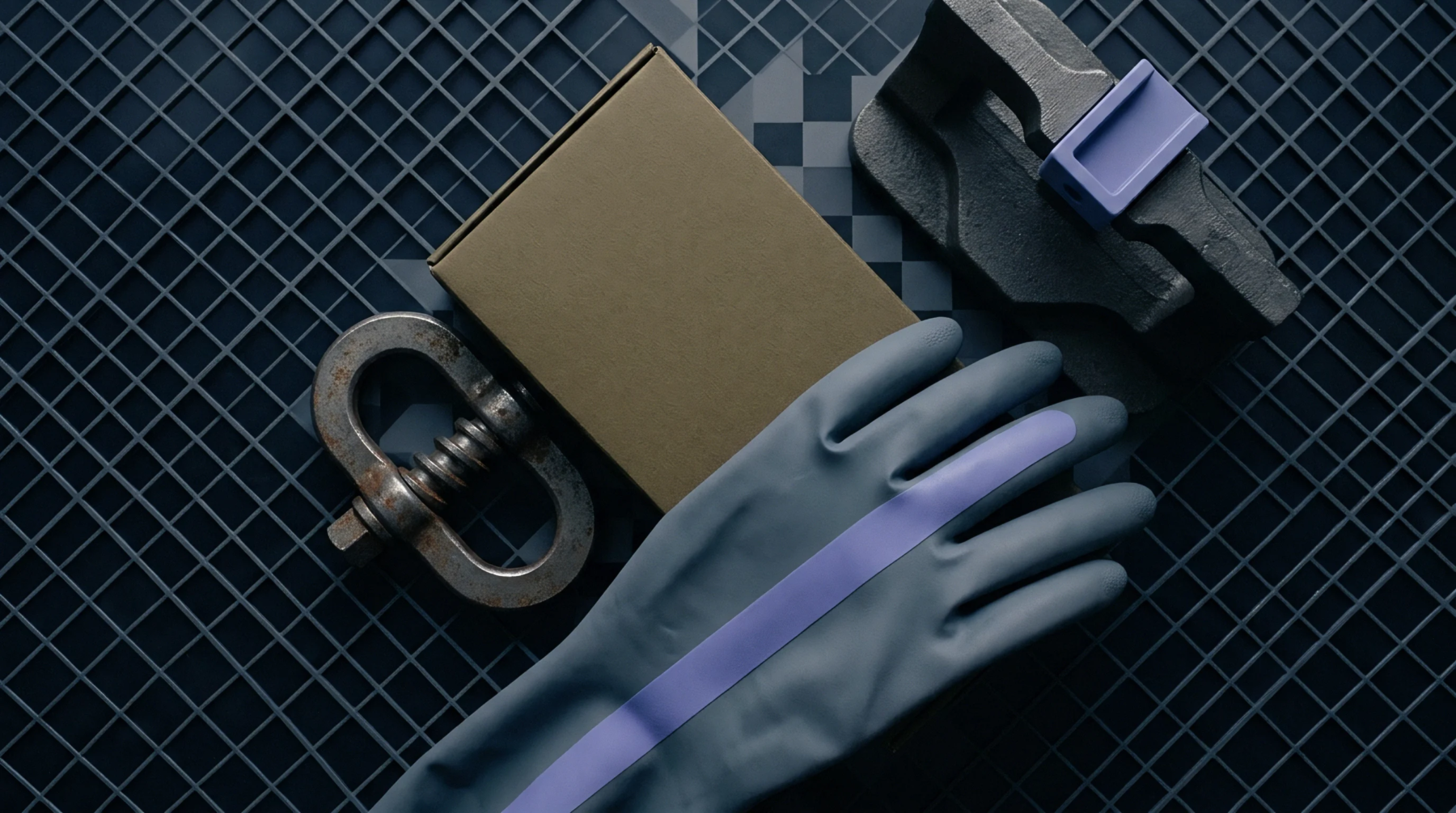 Industrial equipment including a protective glove, a cardboard carton, a steel clamp, and molded packaging lie on a grey mesh grid.